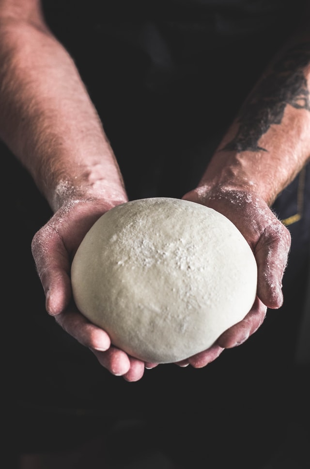 How To Build A Wood Fired Pizza Oven - Person Holding Pizza Dough