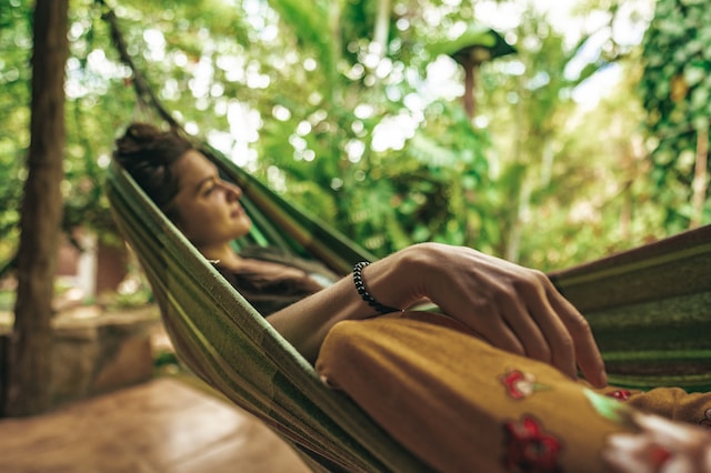 How To Create A Tropical Garden - Woman Sitting In Hammock
